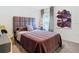 Well-lit bedroom featuring a decorative headboard, modern fixtures, and comfortable bedding at 7737 Sail Clover Ln, Zephyrhills, FL 33540