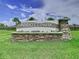 Stone sign at Abbott Park featuring manicured landscaping and palm trees against a beautiful cloudy sky at 7737 Sail Clover Ln, Zephyrhills, FL 33540