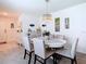 Elegant dining room with a chandelier, a white round table, and plush chairs and tiled flooring at 7737 Sail Clover Ln, Zephyrhills, FL 33540