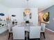 Elegant dining room with a chandelier, a white round table, plush chairs, and open access to other rooms at 7737 Sail Clover Ln, Zephyrhills, FL 33540