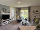 Inviting living room with sliding glass doors, neutral décor, and comfortable seating at 7737 Sail Clover Ln, Zephyrhills, FL 33540