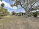Lush backyard featuring a large shade tree and a cozy outdoor seating area at 101 Gulf Blvd, Belleair Beach, FL 33786
