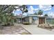 Charming single-story home with mature trees and a cozy front yard seating area at 101 Gulf Blvd, Belleair Beach, FL 33786