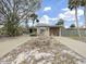Exterior view of a single-story home with a large driveway, a two-car garage, and mature landscaping at 101 Gulf Blvd, Belleair Beach, FL 33786