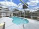 Enclosed pool area with a sparkling pool, light grey deck, and beautiful palm trees at 101 Gulf Blvd, Belleair Beach, FL 33786