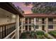 Condo exterior with red tile roof, upper and lower door wreaths, black railings, and mature landscaping at 110 Hammock Pine Blvd # 110, Clearwater, FL 33761