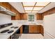Functional kitchen with a white countertop, wood cabinetry, classic appliances, and natural light at 110 Hammock Pine Blvd # 110, Clearwater, FL 33761