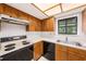 Efficient kitchen featuring wood cabinets, white countertop, and natural light, providing a functional workspace at 110 Hammock Pine Blvd # 110, Clearwater, FL 33761