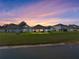 Dusk view of the back of the home, showing the lawn and pond at 11465 June Briar Loop, San Antonio, FL 33576