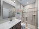 Well-lit bathroom with a modern glass-enclosed shower, vanity with a sink, and contemporary fixtures at 11465 June Briar Loop, San Antonio, FL 33576