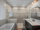 Bathroom featuring a soaking tub, tiled shower, and a dark wood single sink vanity with marble countertop at 11465 June Briar Loop, San Antonio, FL 33576
