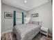 Bedroom with a window dressed in teal drapes and framed art hanging on the walls at 11465 June Briar Loop, San Antonio, FL 33576