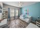 Light and airy bedroom with a blue accent wall, a cozy daybed, and a well-lit workspace at 11465 June Briar Loop, San Antonio, FL 33576