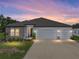 Charming single-story home showcasing stone accents, a well-manicured lawn, and a convenient two-car garage at 11465 June Briar Loop, San Antonio, FL 33576