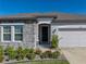 Inviting home entrance with stone accents, colorful flowerbeds, and well-maintained lawn at 11465 June Briar Loop, San Antonio, FL 33576