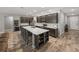 Open kitchen features a large island, stainless appliances, and dark wood cabinets, great for entertaining at 11465 June Briar Loop, San Antonio, FL 33576