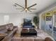 Cozy living room with tile floors, a ceiling fan, and sliding glass doors that lead to a patio at 11465 June Briar Loop, San Antonio, FL 33576