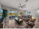 Spacious living room with tile floors, ceiling fan, and sliding glass doors to the backyard at 11465 June Briar Loop, San Antonio, FL 33576