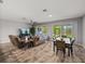 Open-concept living room with a fireplace, dining area, and views of the backyard through sliding doors at 11465 June Briar Loop, San Antonio, FL 33576