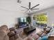 Comfortable living room with ceiling fan, fireplace, and sliding glass doors to the patio at 11465 June Briar Loop, San Antonio, FL 33576