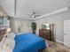 Comfortable main bedroom with tile floors, a tray ceiling, and an entertainment center at 11465 June Briar Loop, San Antonio, FL 33576