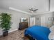 Spacious main bedroom featuring wood-look tile flooring and a decorative trey ceiling with fan at 11465 June Briar Loop, San Antonio, FL 33576