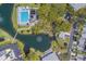 Overhead view of the outdoor pool and sundeck with lounge chairs, trees, water feature, and parking at 11590 Shipwatch Dr # 342, Largo, FL 33774