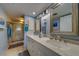 Dual sink bathroom with marble counter tops, a walk-in shower, and blue walls for a relaxing feel at 11590 Shipwatch Dr # 342, Largo, FL 33774