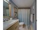 Bathroom featuring marble counter tops, a shower behind a patterned curtain, and framed wall art at 11590 Shipwatch Dr # 342, Largo, FL 33774