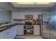 This kitchen features stainless steel appliances and white cabinets with black countertops at 11590 Shipwatch Dr # 342, Largo, FL 33774