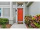 Inviting front door with colorful plants, creating a warm and welcoming entry at 1187 Mistwood Dr, Tarpon Springs, FL 34688