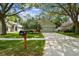Charming home showcasing an attached garage, well-kept lawn, and a vibrant orange front door at 1187 Mistwood Dr, Tarpon Springs, FL 34688