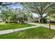 Charming home showcasing an attached garage, well-kept lawn, and a vibrant orange front door at 1187 Mistwood Dr, Tarpon Springs, FL 34688