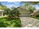 Charming home showcasing an attached garage, well-kept lawn, and a vibrant orange front door at 1187 Mistwood Dr, Tarpon Springs, FL 34688
