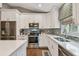 Modern kitchen with white cabinetry, stainless steel appliances, and decorative backsplash at 1187 Mistwood Dr, Tarpon Springs, FL 34688