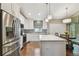 Bright kitchen with stainless steel appliances, white cabinets and island, and wood floors at 1187 Mistwood Dr, Tarpon Springs, FL 34688
