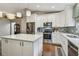 Spacious kitchen featuring white cabinets, a center island, stainless appliances, and tile backsplash at 1187 Mistwood Dr, Tarpon Springs, FL 34688