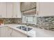 Close-up of the kitchen sink featuring decorative backsplash and a window at 1187 Mistwood Dr, Tarpon Springs, FL 34688