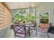 Relaxing screened patio with comfortable seating and ceiling fan overlooking a lush tropical backyard at 1187 Mistwood Dr, Tarpon Springs, FL 34688