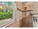 Tiled shower with a glass door and window provides a relaxing view of the outdoor landscape at 1187 Mistwood Dr, Tarpon Springs, FL 34688