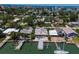Waterfront home with lush landscaping, private boat dock, patio set, and lounge chairs for relaxation at 14043 E Parsley Dr, Madeira Beach, FL 33708