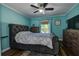 Cozy bedroom featuring light blue walls, a plush bed, and natural light from the window at 14043 E Parsley Dr, Madeira Beach, FL 33708