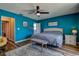 A bedroom painted light blue with a gray upholstered bed featuring natural light and modern decor at 14043 E Parsley Dr, Madeira Beach, FL 33708