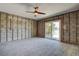 The bedroom shows concrete block walls, a sliding door, and a ceiling fan for comfortable living at 14043 E Parsley Dr, Madeira Beach, FL 33708