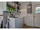 Functional laundry room with modern washer and dryer, storage shelves, and natural light at 14043 E Parsley Dr, Madeira Beach, FL 33708