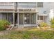 Backyard view of condo featuring a screened patio, foliage, and small tree at 1552 Pleasant Rd # J4, Bradenton, FL 34207