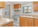 Well-lit kitchen with natural wood cabinetry, white appliances, and view to the community at 1552 Pleasant Rd # J4, Bradenton, FL 34207