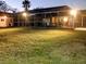 Backyard and screened-in pool area illuminated in the evening at 16403 Bonneville Dr, Tampa, FL 33624