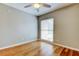 Comfortable bedroom with hardwood floors, a ceiling fan, and a window offering natural light at 16403 Bonneville Dr, Tampa, FL 33624