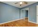 Bedroom features a ceiling fan, hardwood floors, and mirrored closet at 16403 Bonneville Dr, Tampa, FL 33624